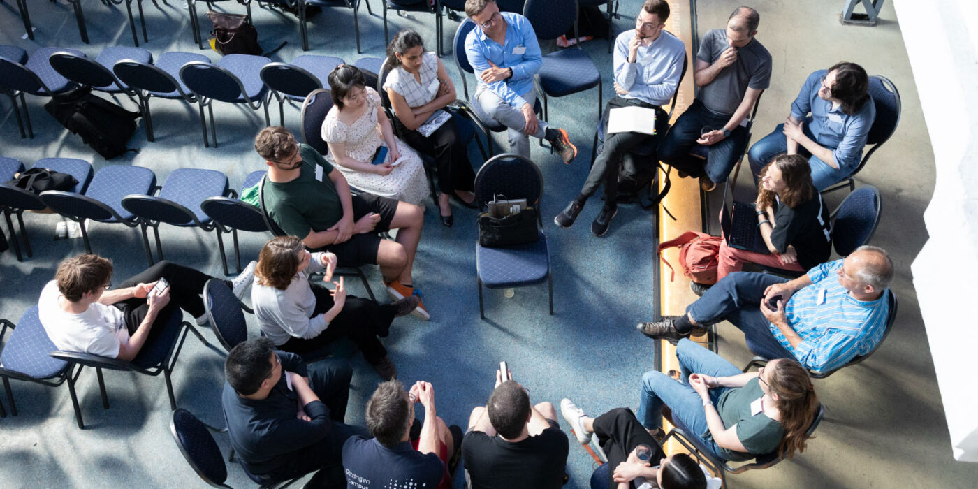 Group of people sitting in a circle; at the Helmholtz Imaging Conference 2024